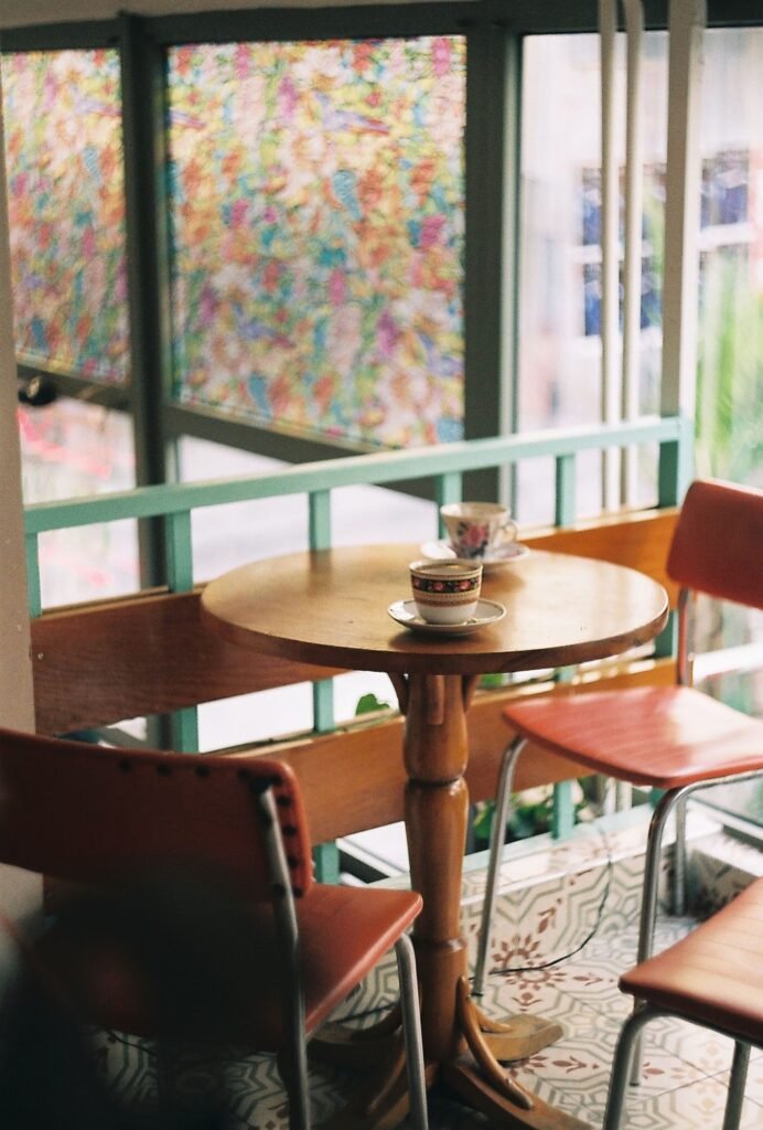 Inviting corner of a cafe with a wooden table and vintage chairs, perfect for a relaxing coffee break.